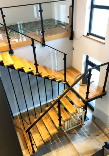 Schody o konstrukcji stalowej z drewnianymi stopniami wraz z balustradą z bezpiecznego szkła 4/4/1 - KIM Ogrodzenia Budzyń