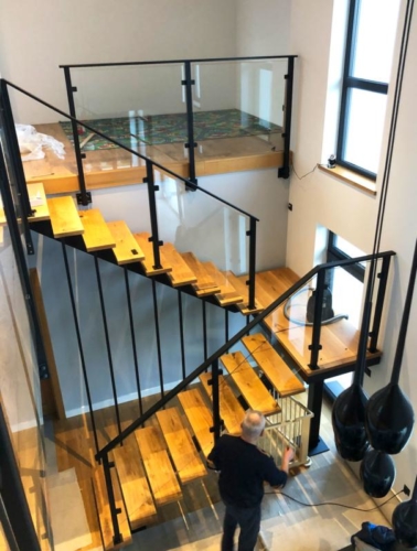 Schody o konstrukcji stalowej z drewnianymi stopniami wraz z balustradą z bezpiecznego szkła 4/4/1 - KIM Ogrodzenia Budzyń