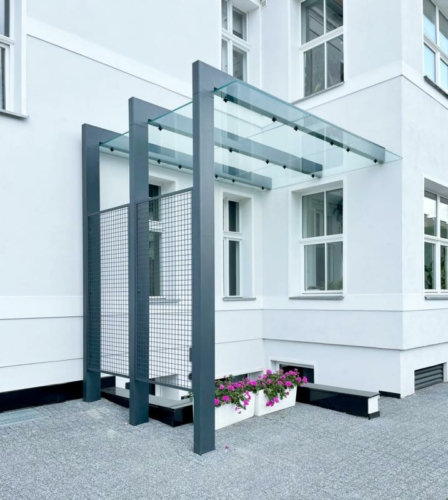 Zadaszenie ze stali, szkła hartowanego i siatki przy zabytkowej kamienicy - KIM Ogrodzenia Budzyń