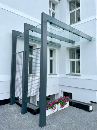 Zadaszenie ze stali, szkła hartowanego i siatki przy zabytkowej kamienicy - KIM Ogrodzenia Budzyń